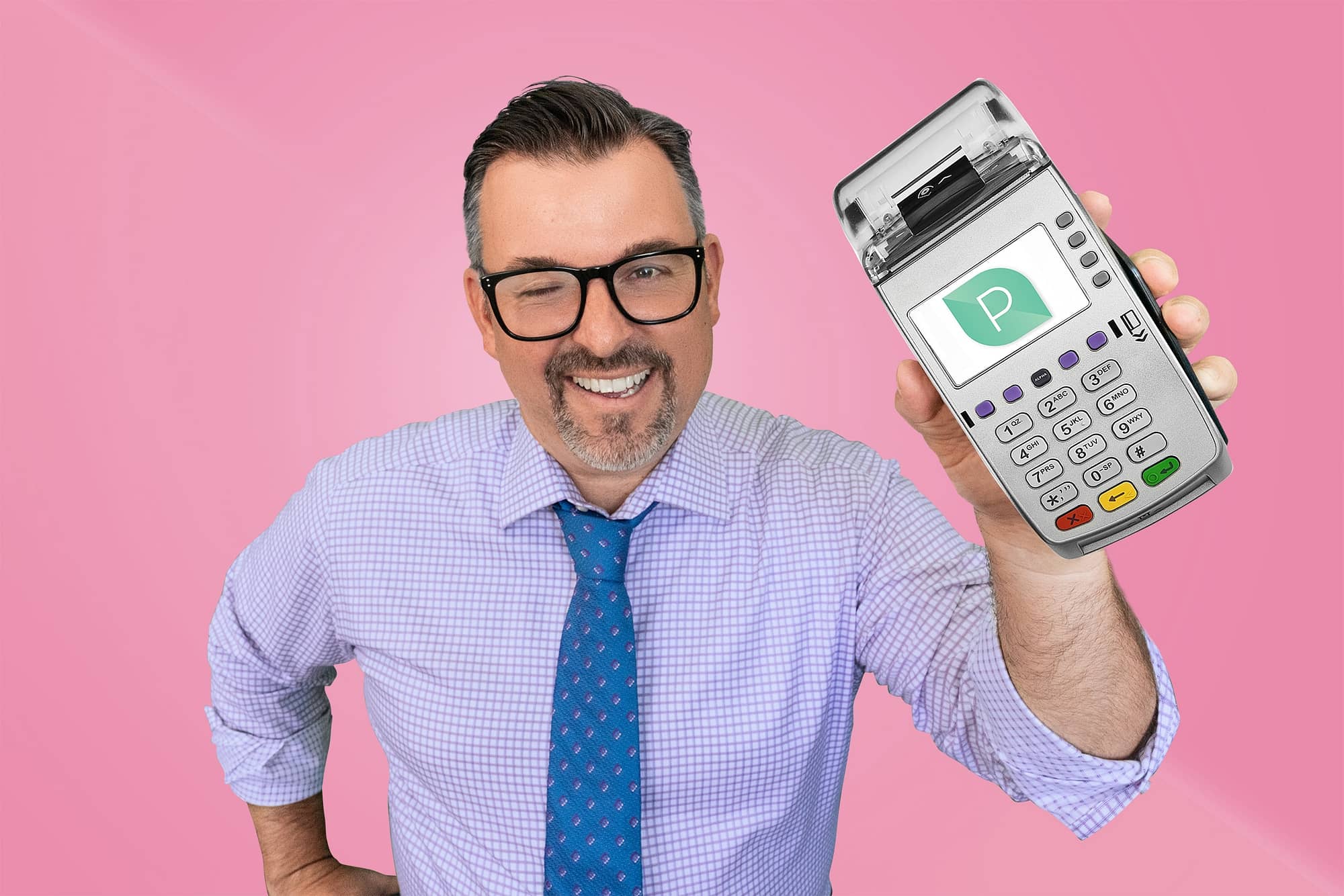 Matt smiling holding up credit card machine on a pink background